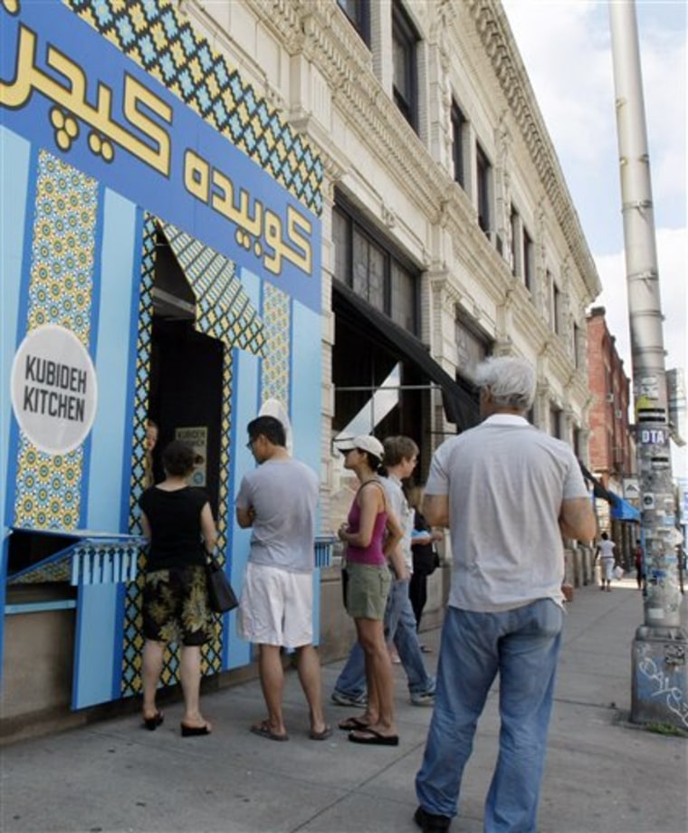 In this May 29, 2010 photo, people line up at the blue and yellow storefront window of the Conflict Kitchen in the East Liberty section of Pittsburgh. The Conflict Kitchen is a takeout cafe designed and run by three artists hoping to open a conversation about countries in conflict with the U.S. by serving one dish from a particular country a month. (AP Photo/Keith Srakocic)